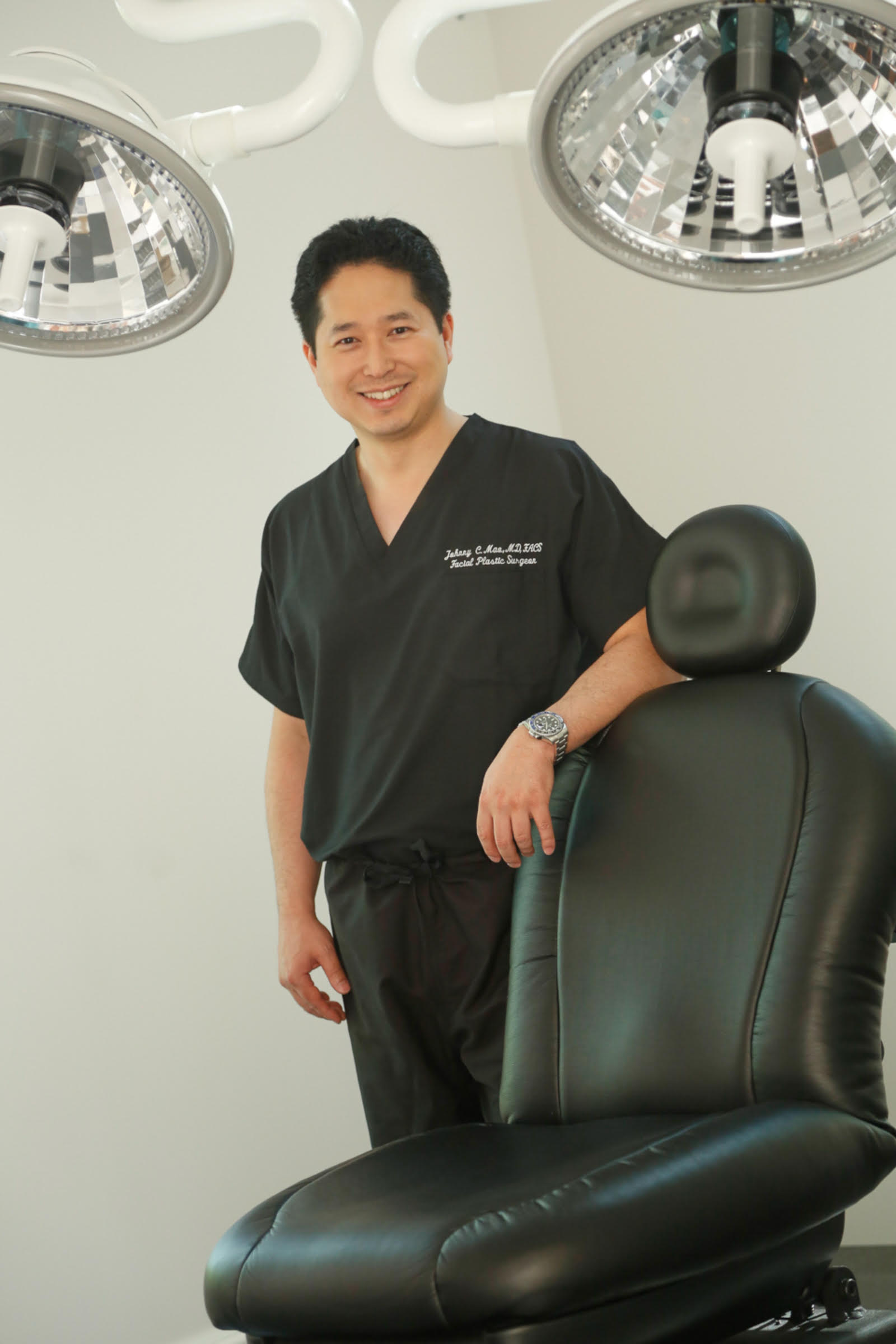 Dr. Johnny Mao in scrubs beside a treatment chair