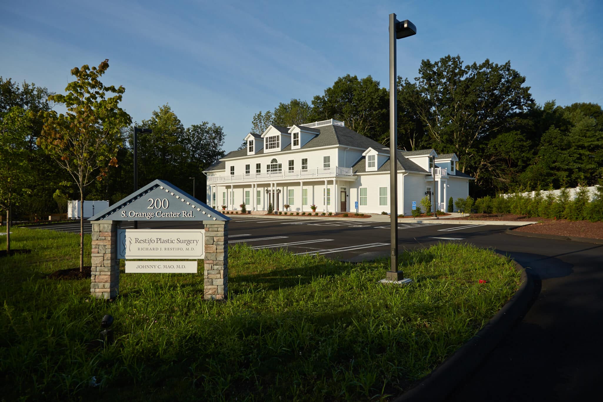 Orange office building and roadside sign for 200 S Orange Center Road