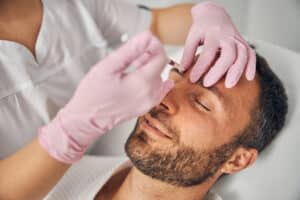 Handsome young man getting cosmetic injections at wellness clinic